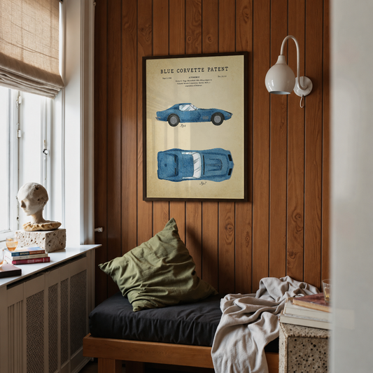 Blue Corvette patent print framed above a bed in a bedroom