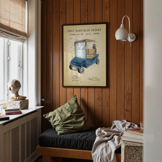 Blue golf cart patent print framed above a bed in a bedroom