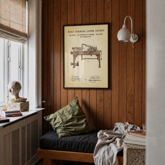 Wood turning lathe patent print framed above a bed in a bedroom