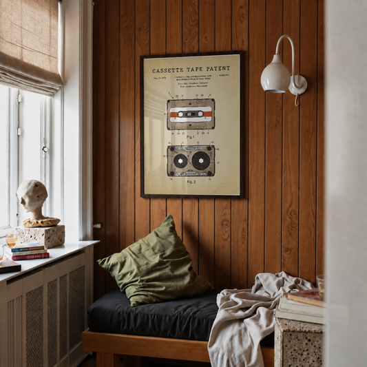 Cassette tape patent print framed above a bed in a bedroom