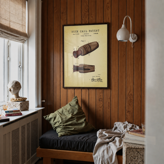 Duck call patent print framed above a bed in a bedroom